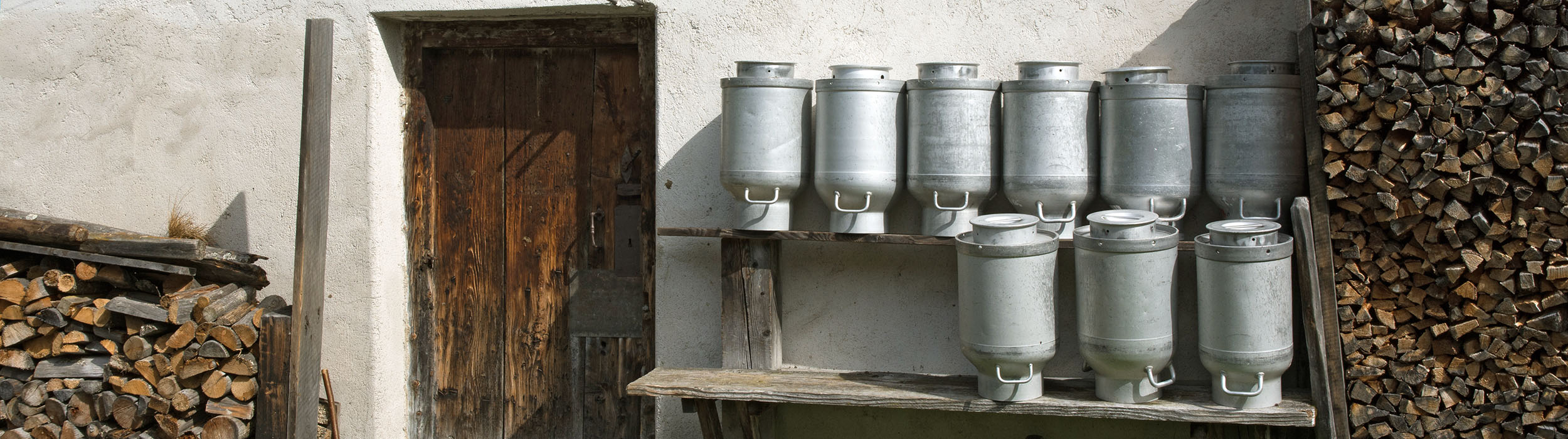 Gestapelte Milchkannen auf der Alm Milchkannen